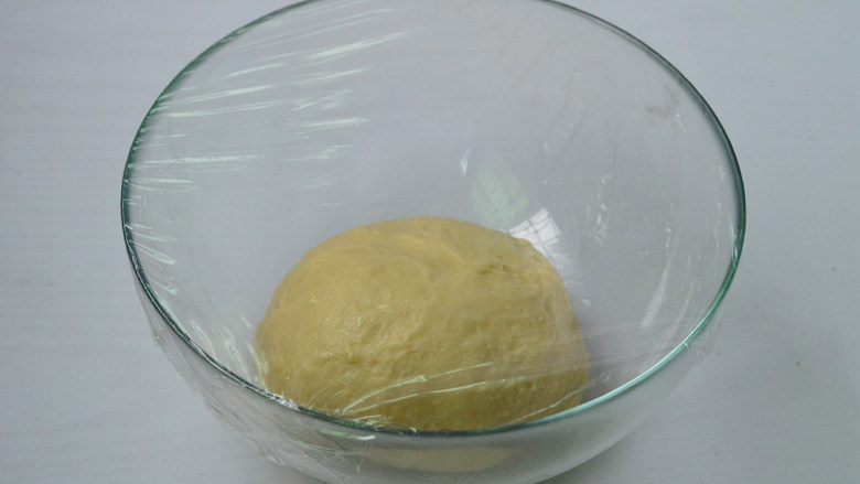 扁桃仁餐包,将面团揉圆后放入碗中，盖上保鲜膜放置温暖处发酵约60分钟（冬季温度低，时间约2小时）
