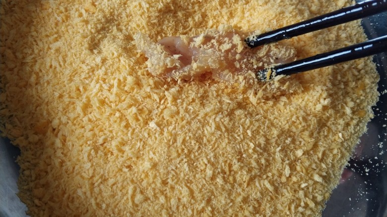 黄金鸡柳（两种做法）,把鸡肉条放入面包糠中滚几下，使鸡肉条都粘满面包糠