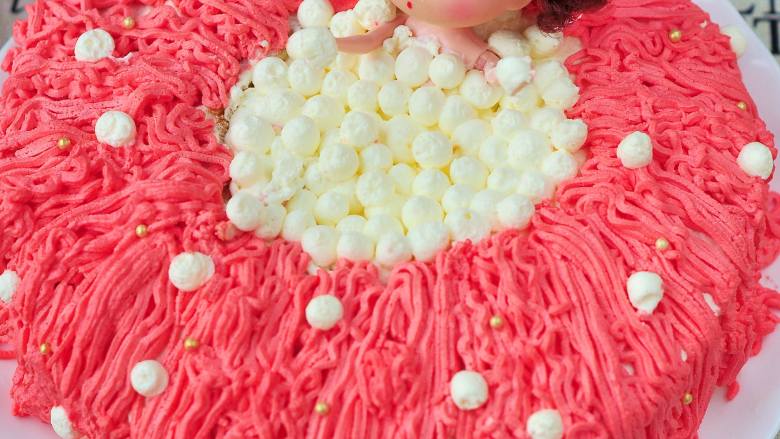 泡澡娃娃蛋糕,用蒙布朗花嘴挤出红色线条，中间用圆形花嘴挤上泡泡，最后撒上金珠糖做装饰。