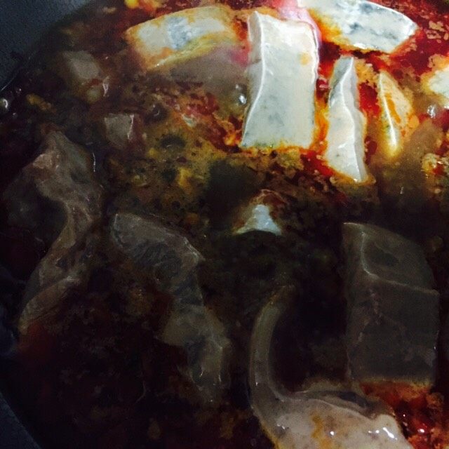 豆瓣泡椒鱼,锅中水烧开后小火熬煮一会儿，放入鱼块先放鱼头煮一会儿再放鱼肉