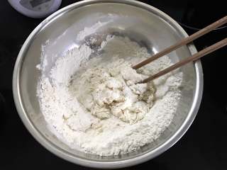 生煎包子,用牛奶把酵母融化后倒入面粉中和成面絮。