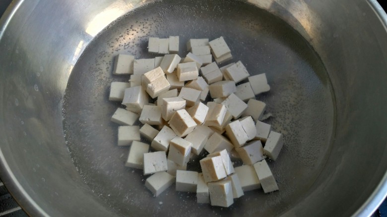 麻婆豆腐,起锅烧水，水开把豆腐放入煮一分钟。用开水焯豆腐可以去除豆腥味，也可以保持豆腐形状不易碎。