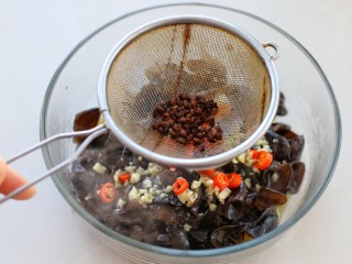凉拌脆爽黑木耳,然后用筛网滤出花椒粒，将热油浇到蒜末和米椒段上爆香