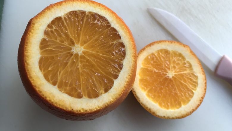 盐蒸橙子（止咳功效）,用小刀切去橙子一部分，露出橙子肉。