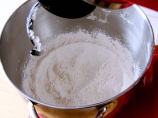 粗粮长棍面包,高筋粉、全麦粉、泡打粉、盐和糖都倒入厨师机，搅拌均匀。