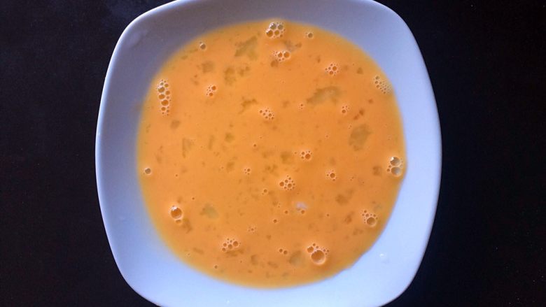 油炸芒果酸奶,取一个盘子，打入鸡蛋，并迅速搅拌均匀。