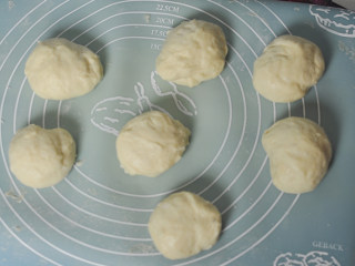 肉松面包, 取出发酵的面团，分为7等份，收圆后盖上保鲜膜松弛15分钟