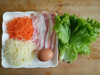 鸡蛋灌饼,醒面的空准备蔬菜。将胡萝卜和土豆切细丝，生菜洗净。