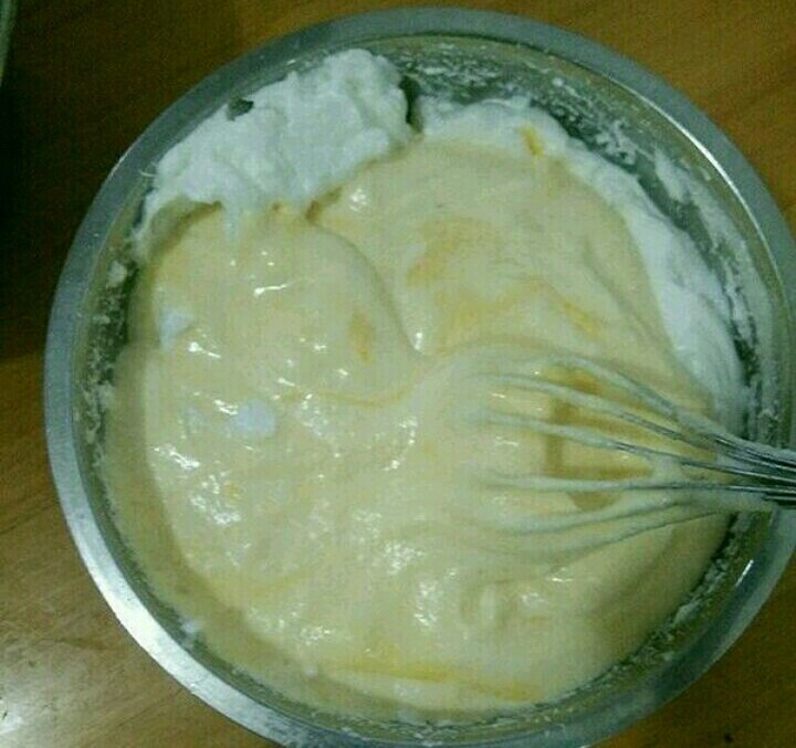 酸奶淋面蛋糕,然后倒回蛋白糊，继续翻拌至顺滑。把蛋糕糊倒进模具里，在垂直桌面20里面的距离，震一下模具，震出大气泡。