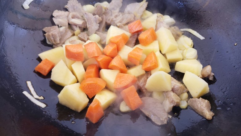 砂锅土豆西红柿炖牛肉,再加入土豆和胡萝卜炒