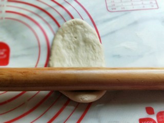 香葱培根芝士面包,取一块面团，压扁，擀长舌状，依次擀出长舌状，放入烤盘中，送进烤箱二次发酵，可以再烤箱内放一碗开水，保证湿度环境。