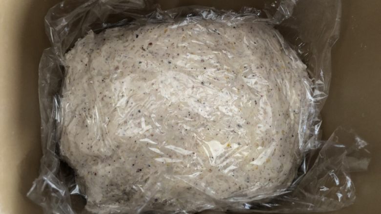五谷桂圆软欧,混合好的面团铺平在面包机中，盖上保鲜膜静置5分钟，再打开发酵功能，发酵60分钟