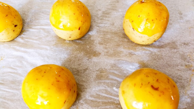 伪蛋黄酥～红薯豆沙球,把红薯球刷上一层蛋液，依次全部刷完，预热烤箱，上下火175度10分钟左右