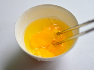 胡萝卜芝士蛋卷,鸡蛋打入碗中，用筷子搅匀