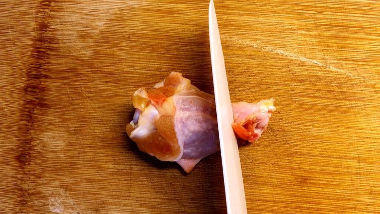 香烤鸡翅根,用刀在鸡翅根的底部切一圈，切断皮肉和筋膜。