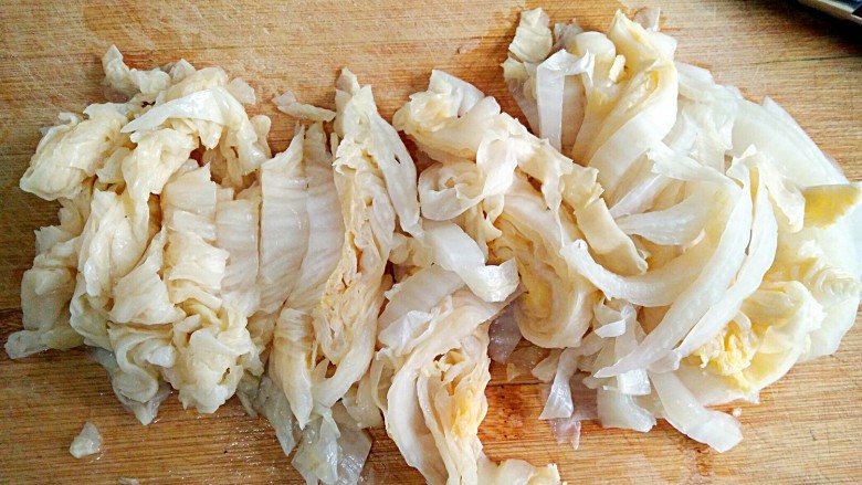 酸菜丸子粉丝煲,将洗净的酸菜切成宽0.7厘米左右的丝。