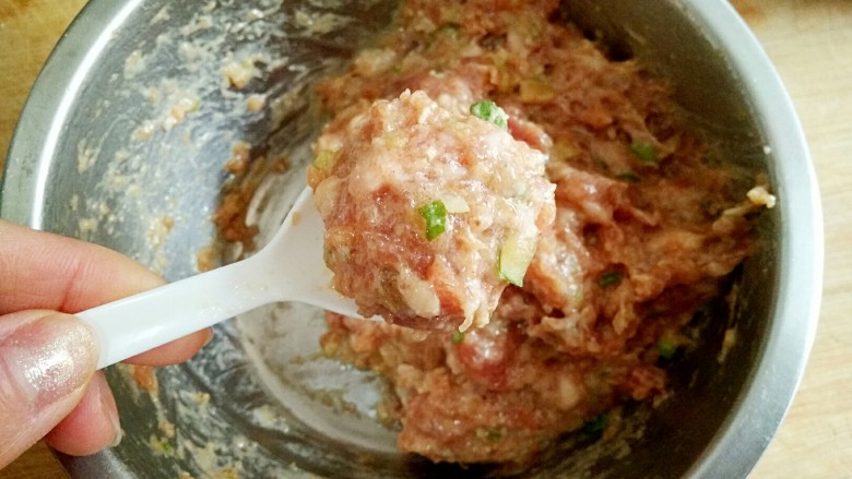 酸菜丸子粉丝煲,搅好的肉馅用小勺子挖成丸子。