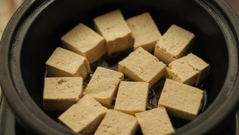 酿豆腐,锅里倒油，将有肉馅的一面朝下摆入锅里，小火慢煎