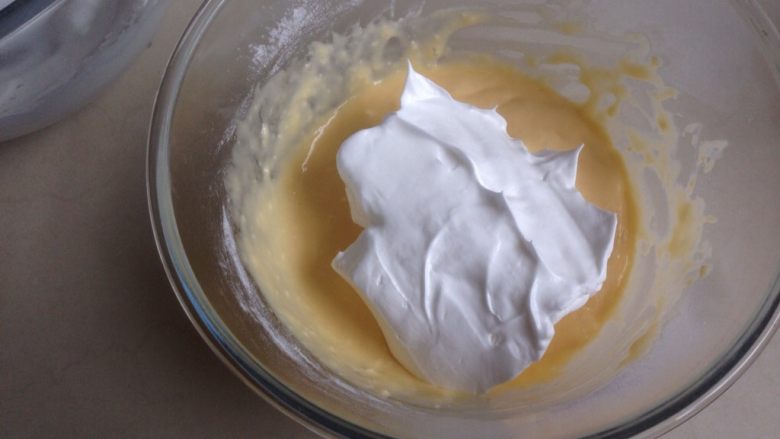 不上火的蒸蛋糕,取三分之一打发好的蛋白霜，放入到蛋黄糊里，用刮刀从底部向上翻拌均匀，不要划圈搅拌。