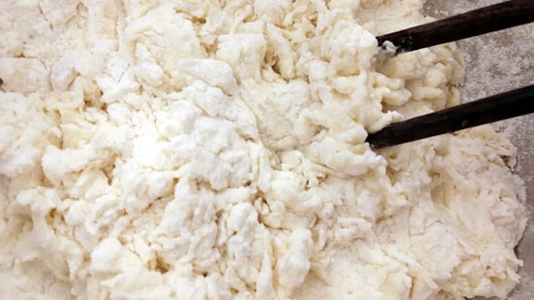 发面版酥烧饼（两种口味）,把酵母水倒入面粉中，余下的温水也逐步加进面粉里面，一边用筷子快速搅拌成棉絮状态