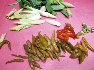 泡椒炒腊肉,泡椒切成小段，蒜苗切成段。
