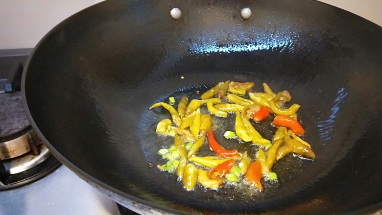 泡椒炒腊肉,锅中放适量油烧热，放入泡椒炒出香味。