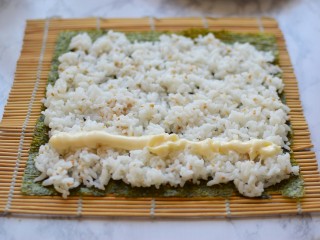 金枪鱼寿司卷,米饭放在海苔上，按实，挤上沙拉酱