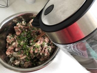 鲜肉虾仁韭菜小馄炖,韭菜加入，顺时针搅拌均匀，然后加入一点点水，这样可以使肉馅容易成团，不易散开，包的时候也好包。