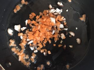 菠萝造型炒饭,锅中放入少许油，倒入胡萝卜和香菇丁翻炒