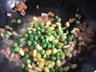 菠萝造型炒饭,胡萝卜断生后加入豌豆和玉米继续翻炒