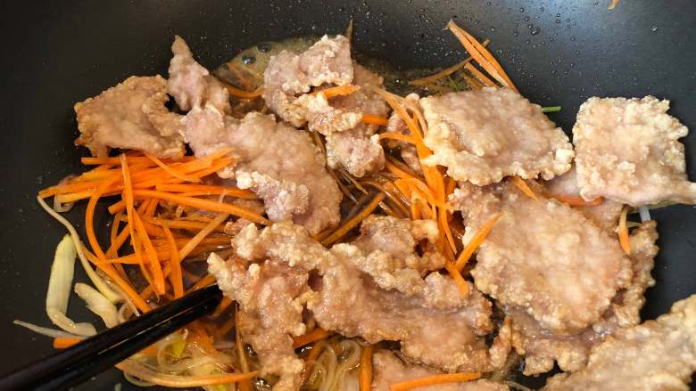 锅包肉,放入肉片和胡萝卜炒匀