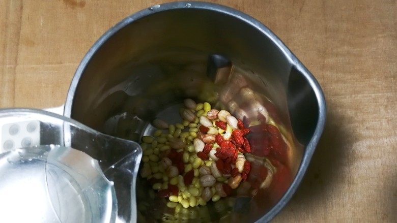 黄金养生枸花黄豆浆,放入适量清水，在豆浆机里面上下刻度之间