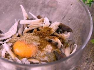鲜菇,鲜菇挤干水分，打入鸡蛋、盐、胡椒粉、孜然粉、椒盐粉、面粉