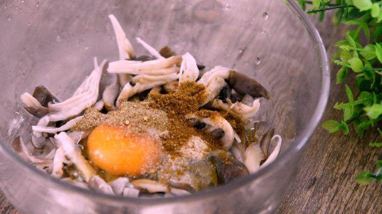 鲜菇,鲜菇挤干水分，打入鸡蛋、盐、胡椒粉、孜然粉、椒盐粉、面粉
