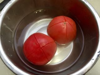 红红火火，幸福生活➕番茄金针肉末羹,盆中放入开水，浸泡番茄几分钟，番茄外皮会卷起容易剥皮