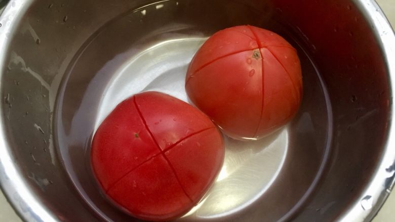红红火火，幸福生活➕番茄金针肉末羹,盆中放入开水，浸泡番茄几分钟，番茄外皮会卷起容易剥皮