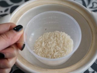 皮蛋瘦肉粥,砂锅里倒入一小撮的大米。
