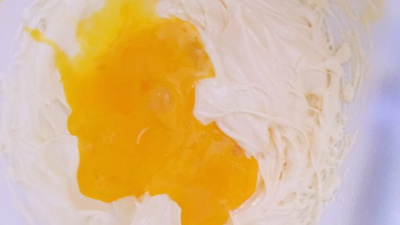 超好吃的椰蓉球,先加一半的蛋黄到黄油里，用打蛋器搅打至充分混合，一定要分两次加入哦，避免水油分离