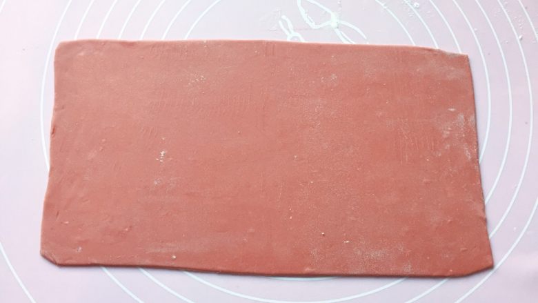 如意花卷,将发酵好的面团分别排气揉匀后，先取红色面团擀成宽12cm 长25cm的薄片。