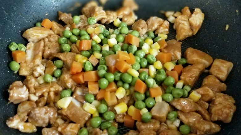 【快手下饭菜】豌豆炒鸡丁,再加入焯水的胡萝卜丁，豌豆，玉米粒煸炒。