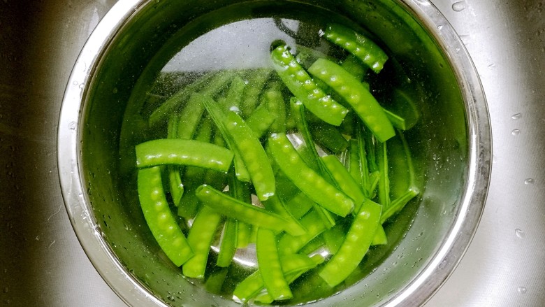 蒜蓉荷兰豆,放入冷水中冲凉，以保持荷兰豆翠绿的颜色和轻脆的口感。