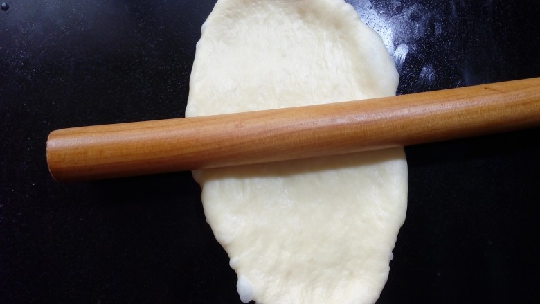 #花样吐司#波兰酵头酸奶吐司,取一面团，正面向下，用擀面杖从中间分别往上、往下擀开。 
