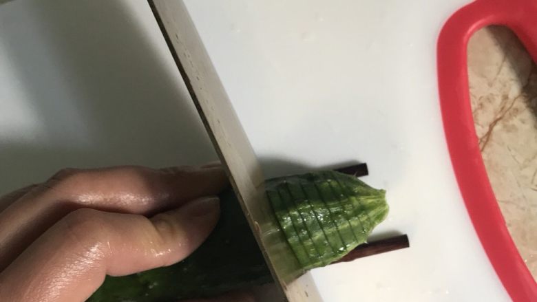 簑衣黄瓜,左手的大拇指和无名指分别把着两边的筷子 垂直着切薄片