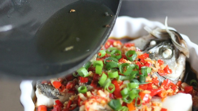 剁椒鱼头,锅中烧热油淋在葱上，完成。