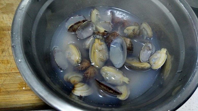 海鲜疙瘩汤,汤和蛤蜊一下放在一个盆中，把蛤蜊去皮留肉，把肉放在汤水中浸泡。
