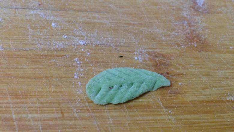 太阳花枣馍,取少许绿色面团搓成水滴形，
压扁，用牙签压出叶脉