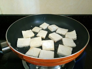 椒香脆皮豆腐,平底锅放适量油加热，豆腐码上，中火煎