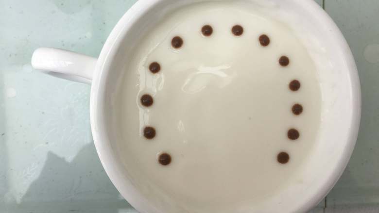 酸奶拉花之蒲公英,在酸奶中先用可可粉挤上一圈小圆点