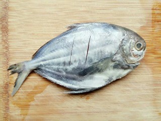 年年有鱼:香煎柠檬鱼,将鱼冲洗干净后放占板往鱼身划两刀
