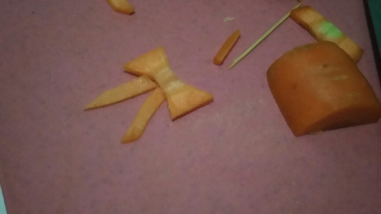 花环沙拉🌸,拿一个干净胡萝卜，我们来制作蝴蝶结🎀，手法生疏的小伙伴可以先用牙签在胡萝卜上画出蝴蝶结的形状。记得选较粗的那一段哦。